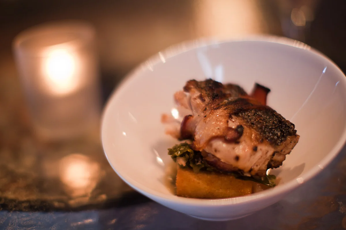 Seared wild striped bass, crispy grits, pecanwood bacon, braised greens, vanilla-bourbon vinaigrette
