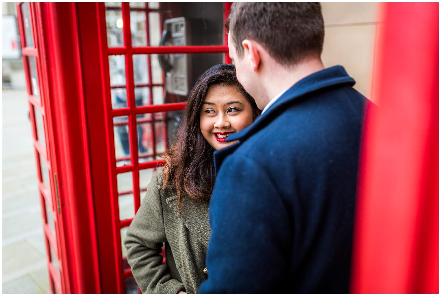couple between old red phone boxes