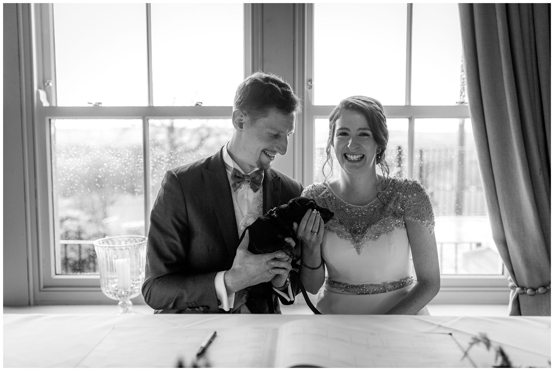 bride and groom signing the register with their dog