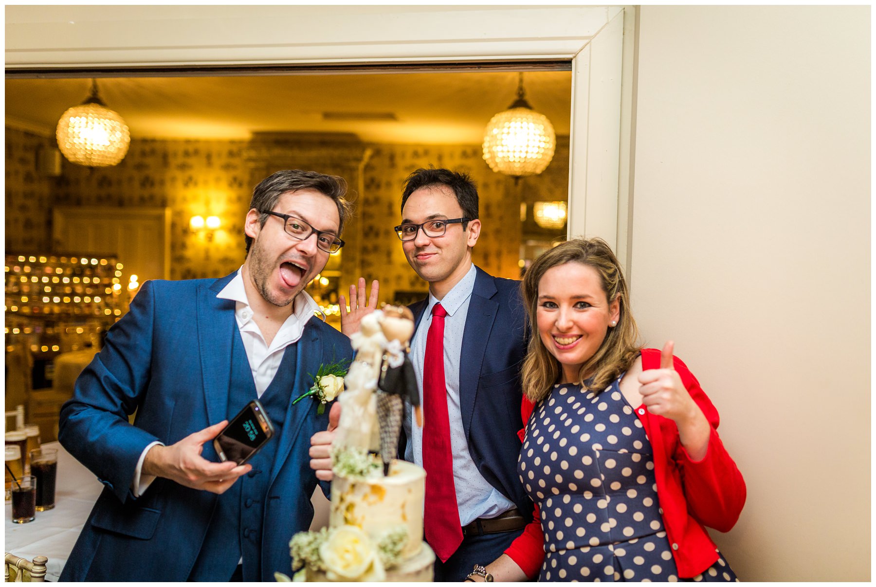 guests posing with wedding cake