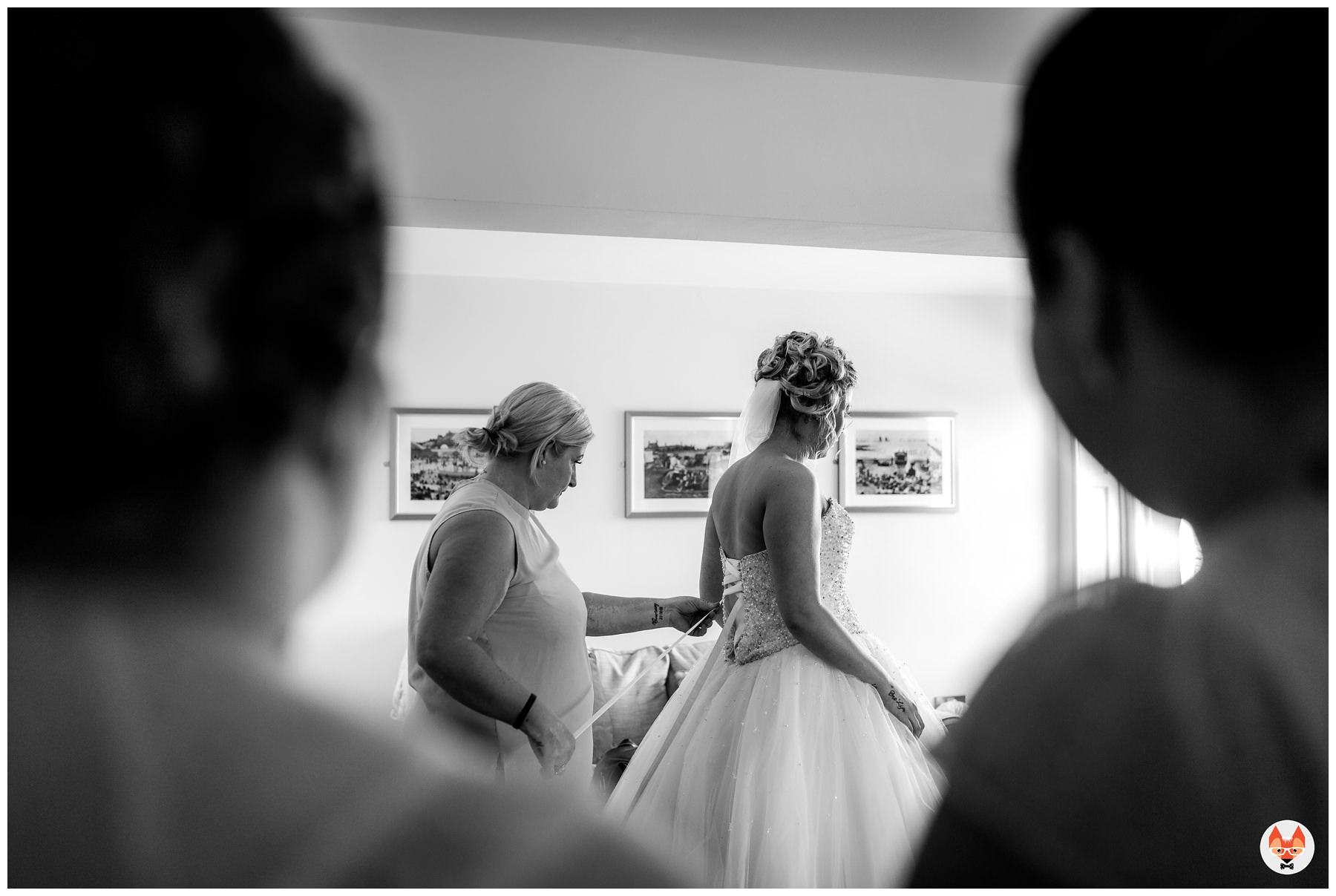 bride having her dress fastened up