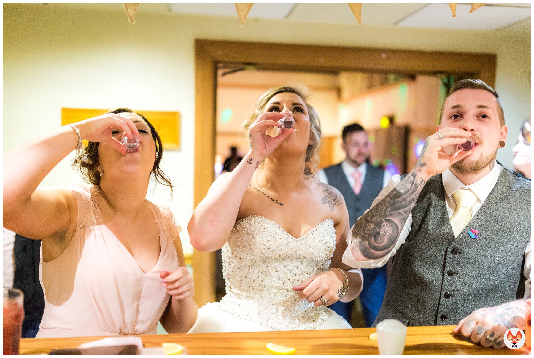 bride and groom doing shots at the bar