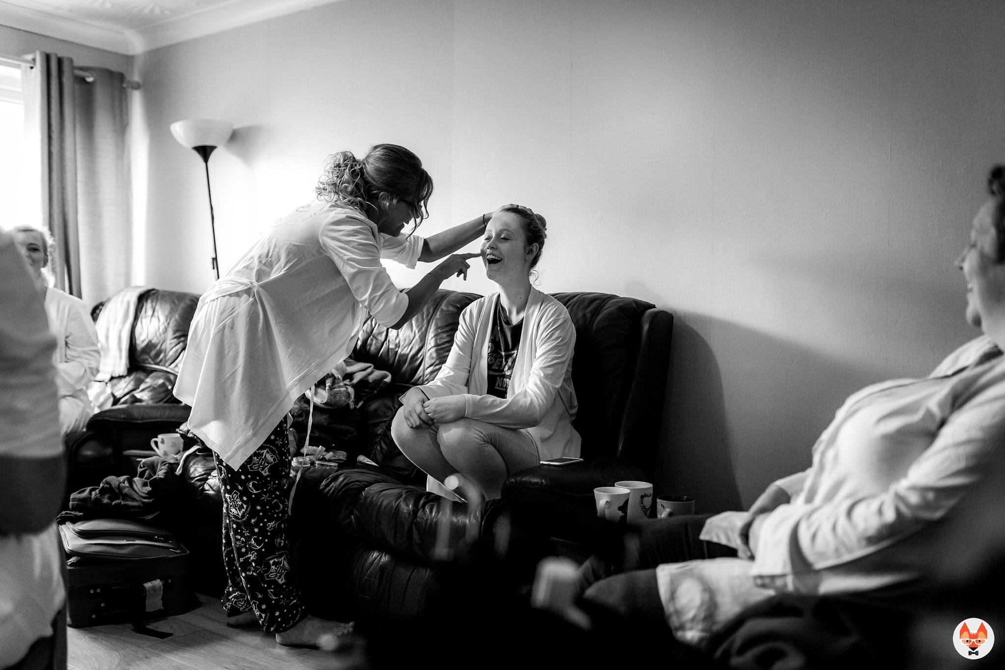 bride helping sister with makeup