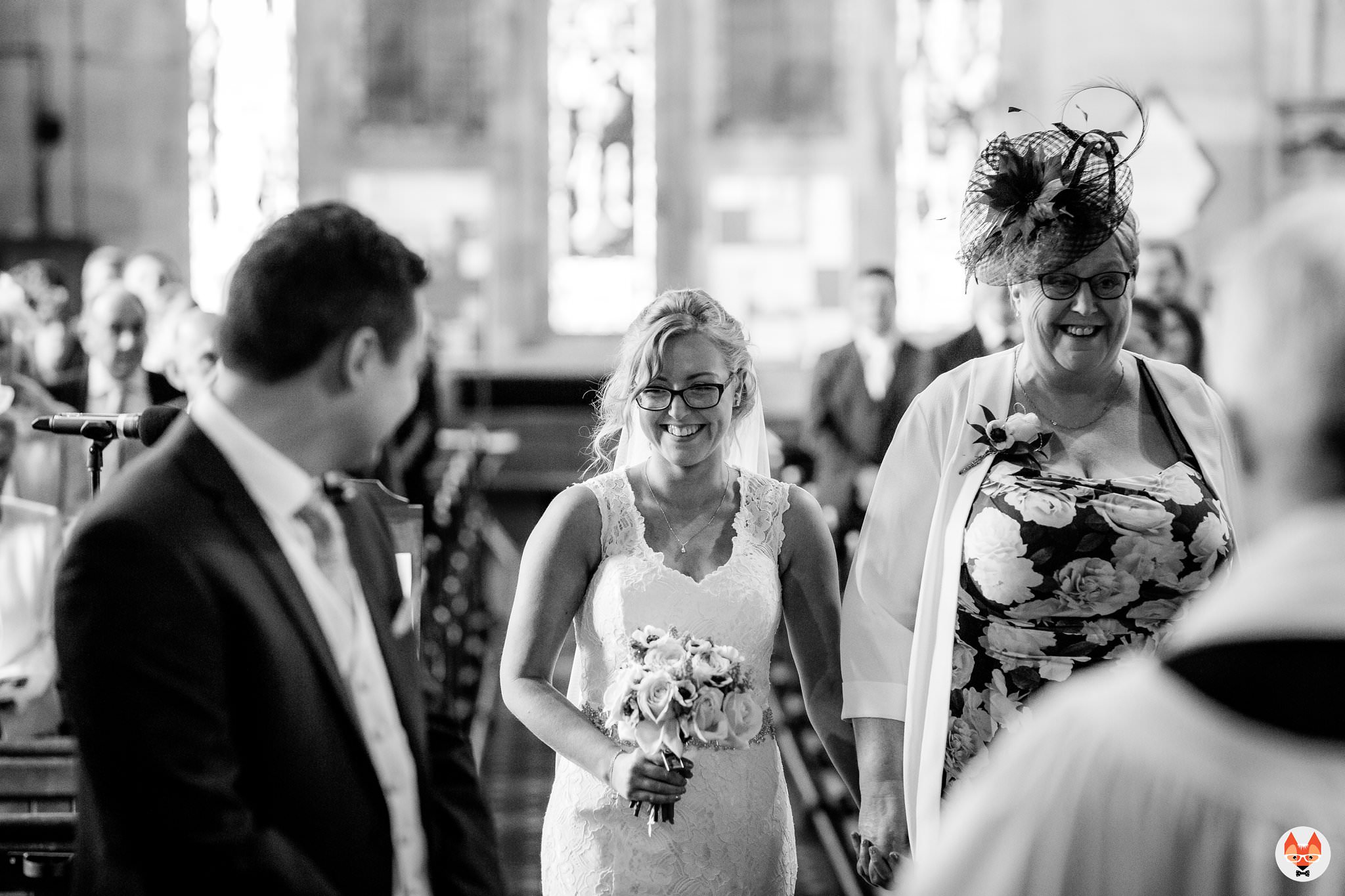 bride smiling as she walks up the aisle