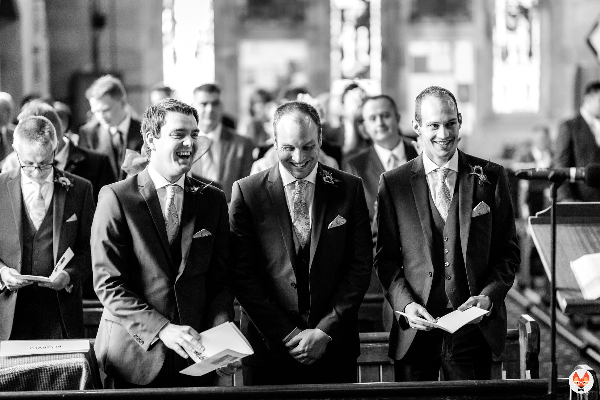 groomsmen laughing during the service