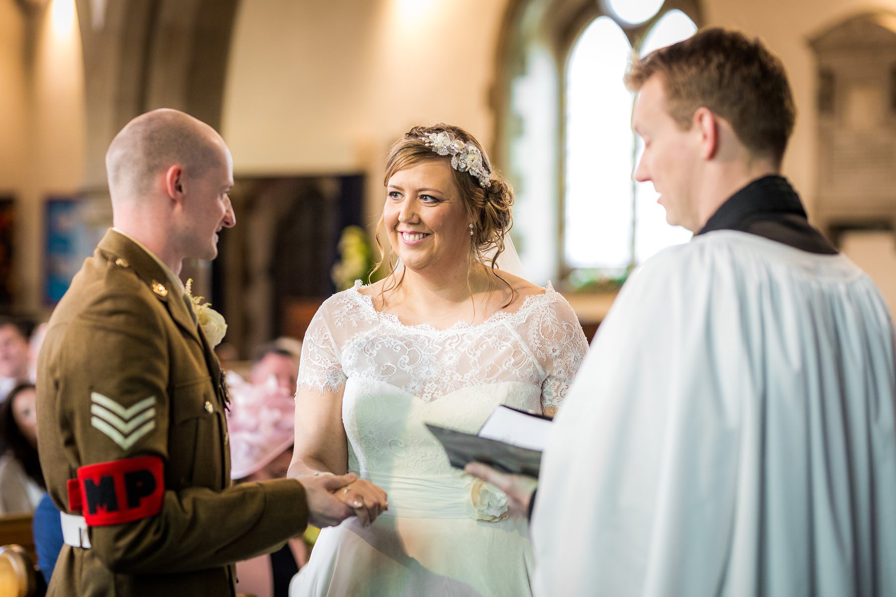 bride and groom smiling during wedding service