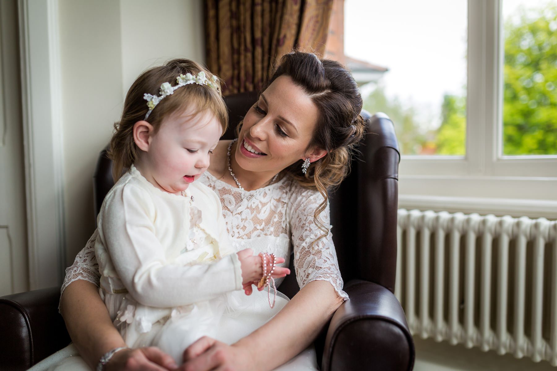 flower girl sat on brides knee