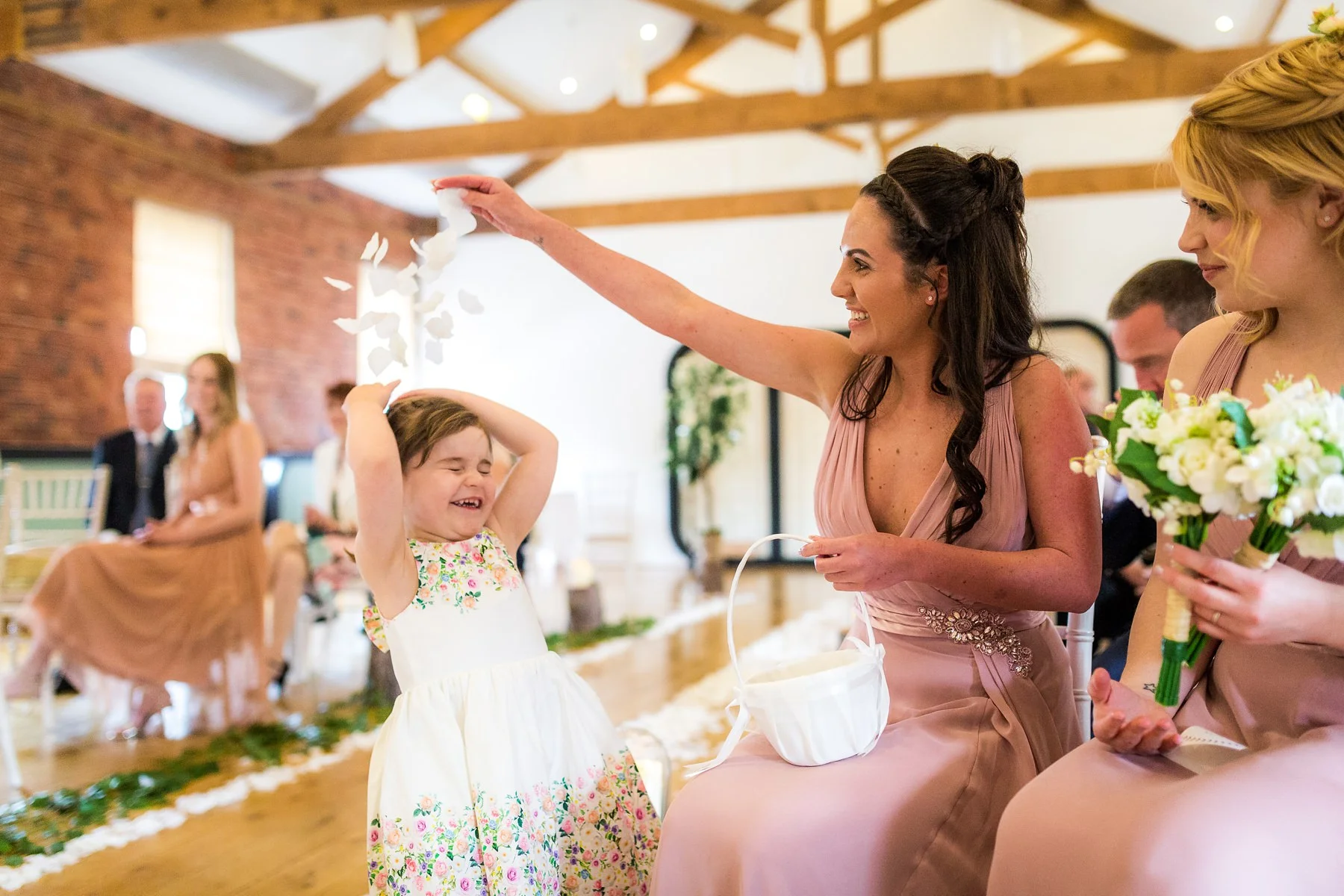 bridesmaids playing with flower girl