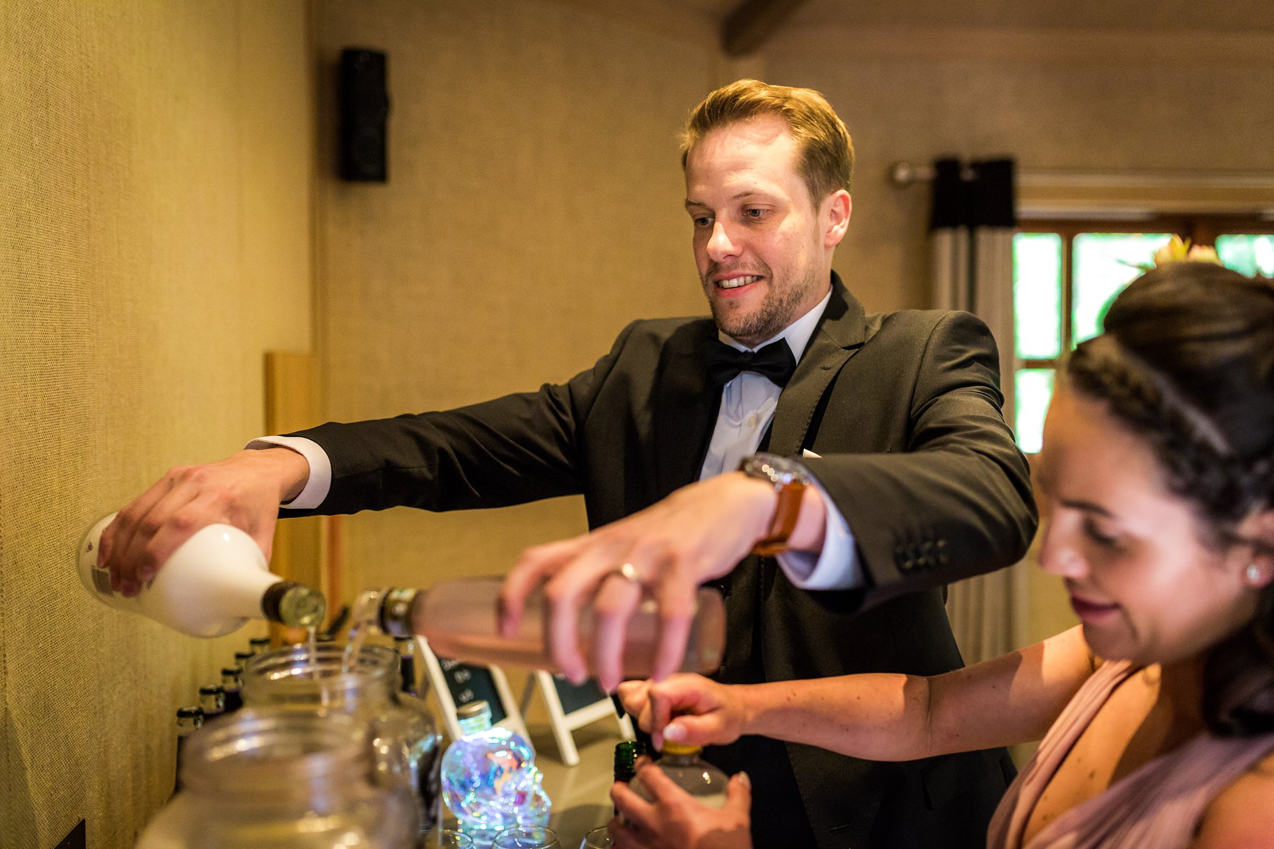 groom making his own cocktails