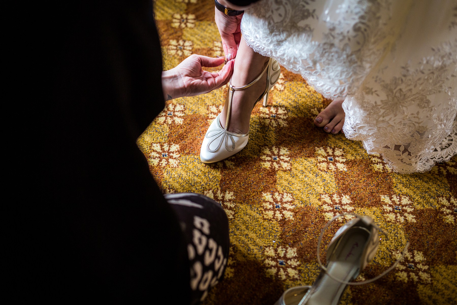bride putting on her wedding shoes