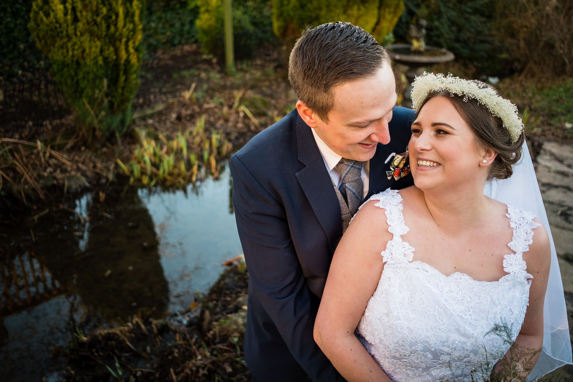 bride and groom by pond at stirk house