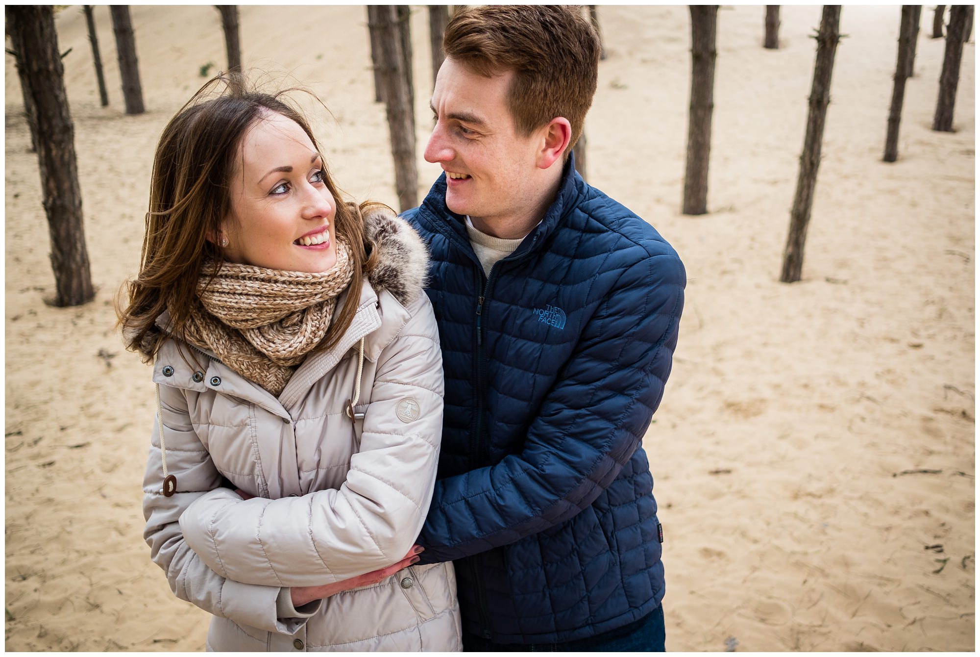 groom to be cuddling his fiancé