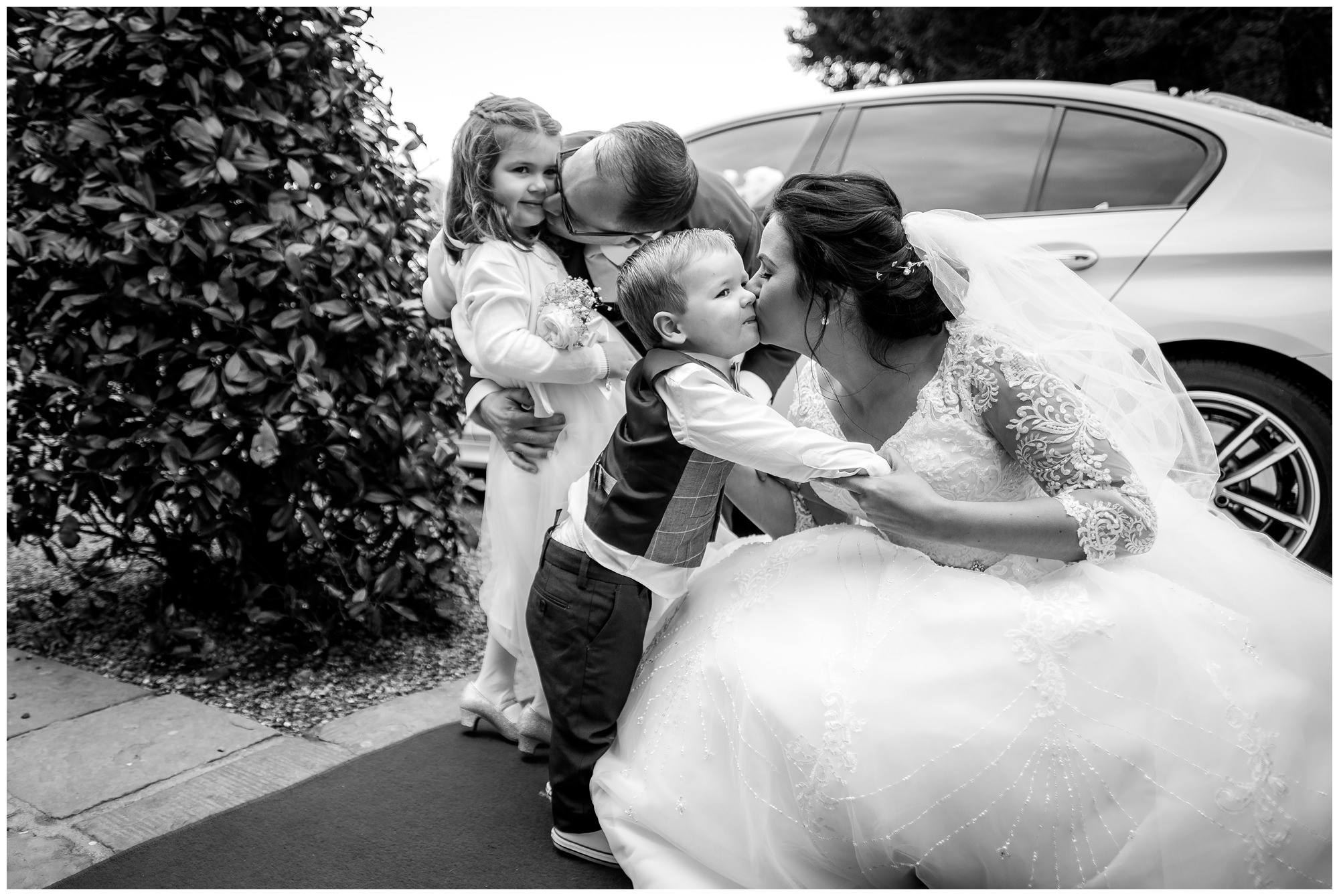 bride and groom kissing their children