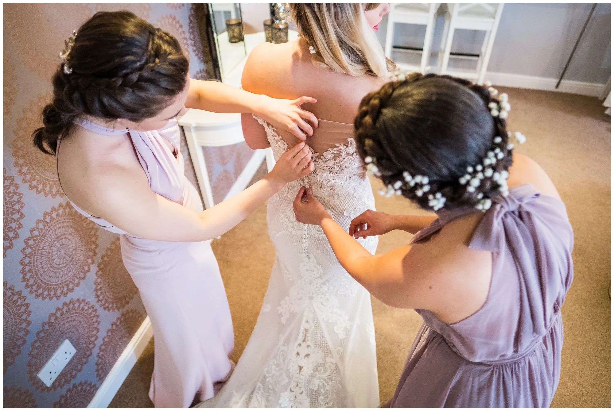 bridesmaids helping with wedding dress