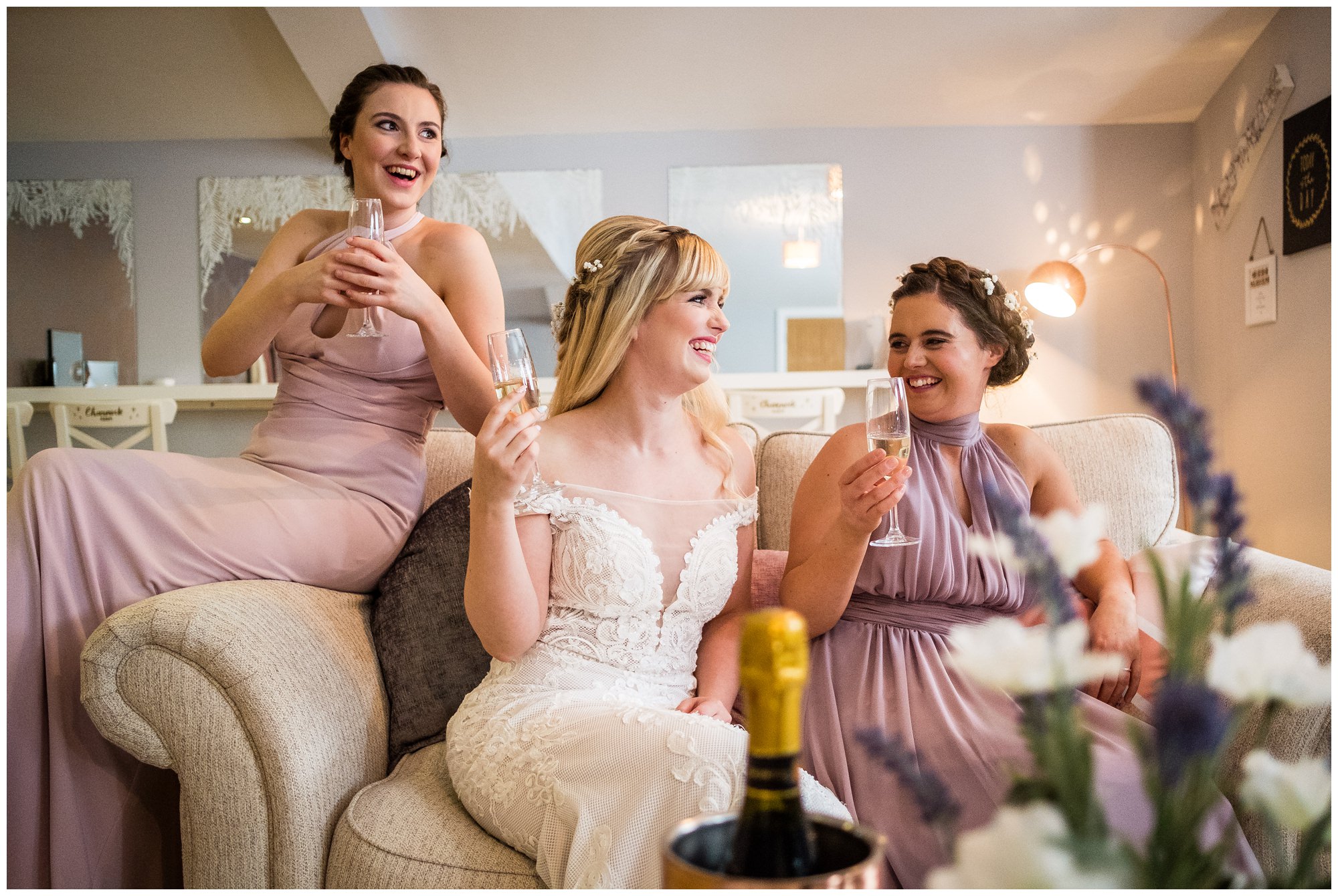 bride and bridesmaids laughing on couch