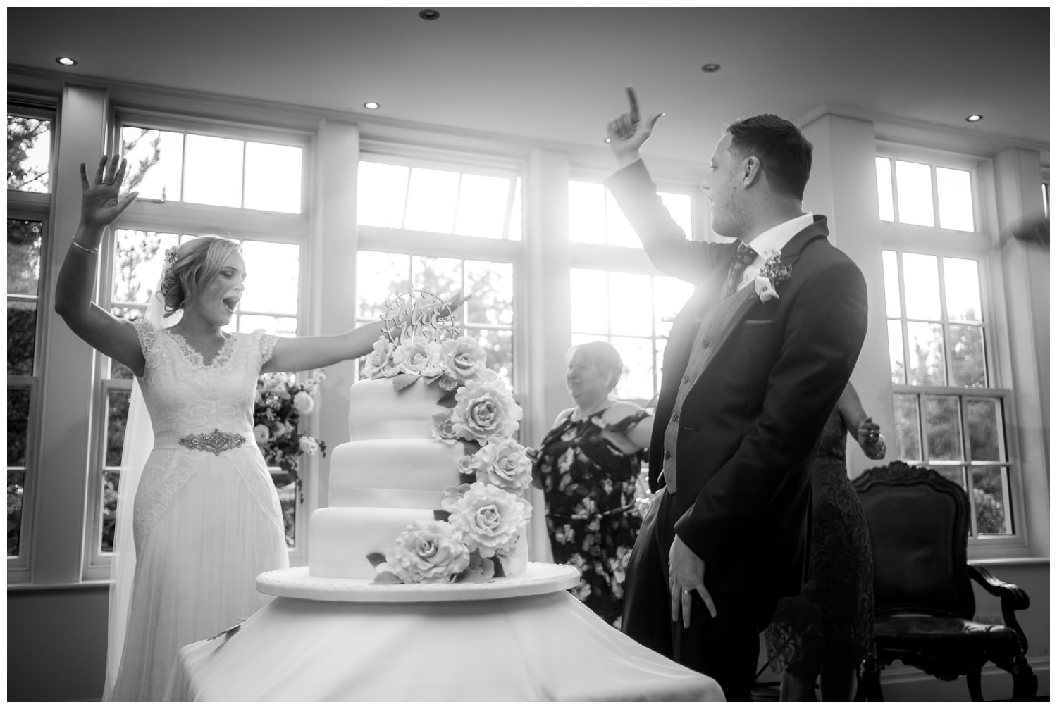 bride and groom cheering after cutting their wedding cake