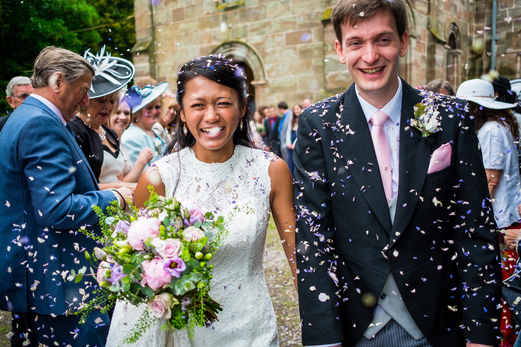 bride and groom walking through confetti