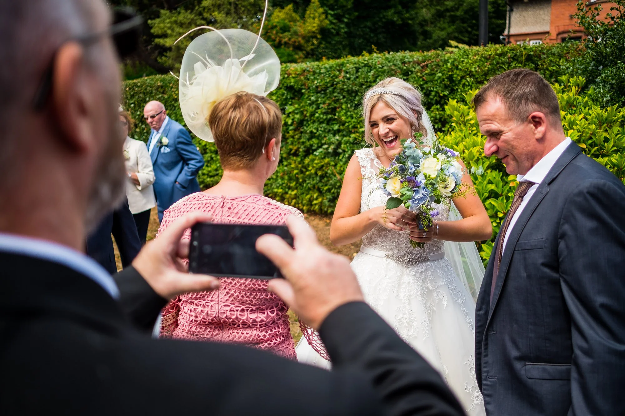 guest taking a photo of bride