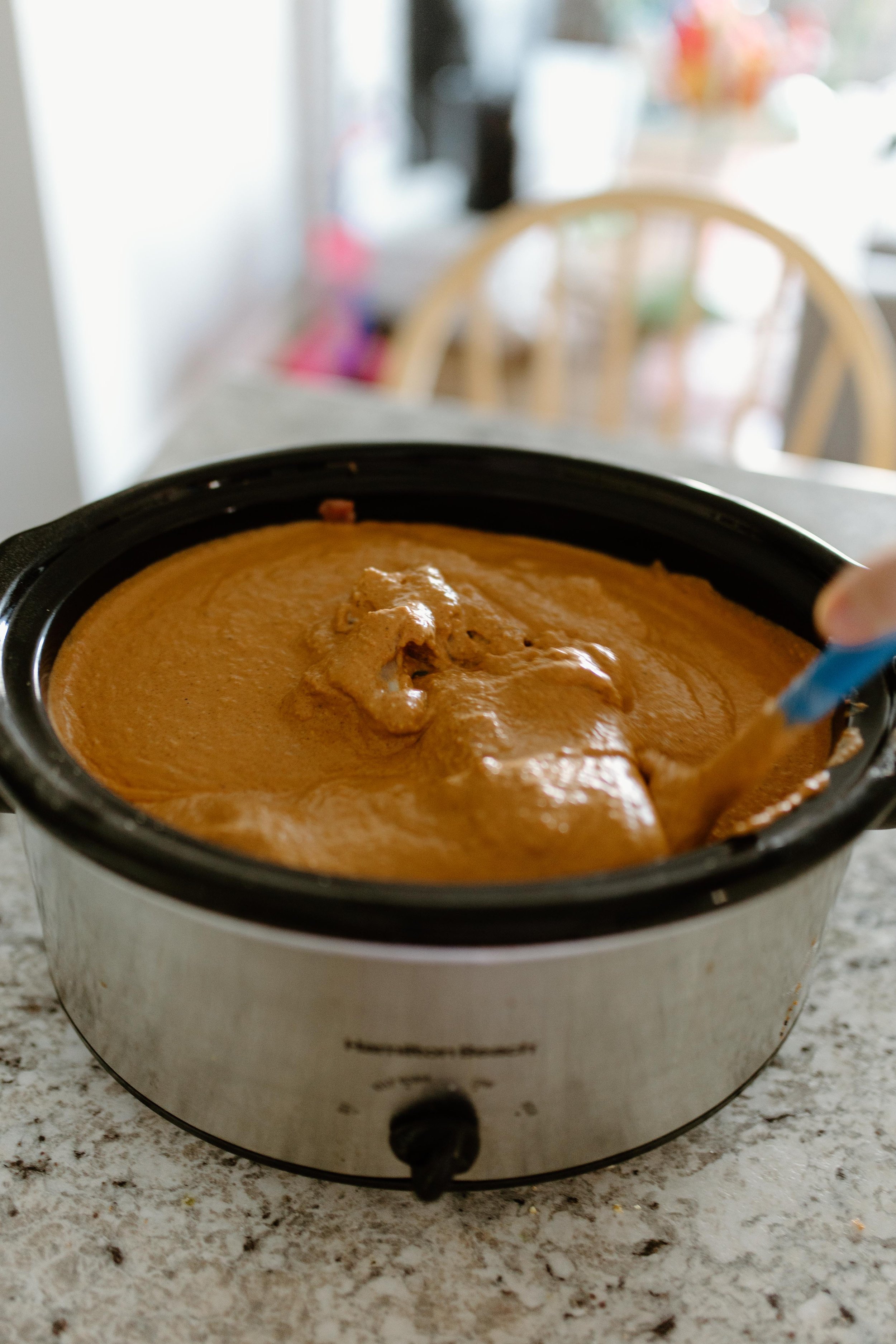The Best Slow Cooker Butter Chicken in the crockpot stirring.