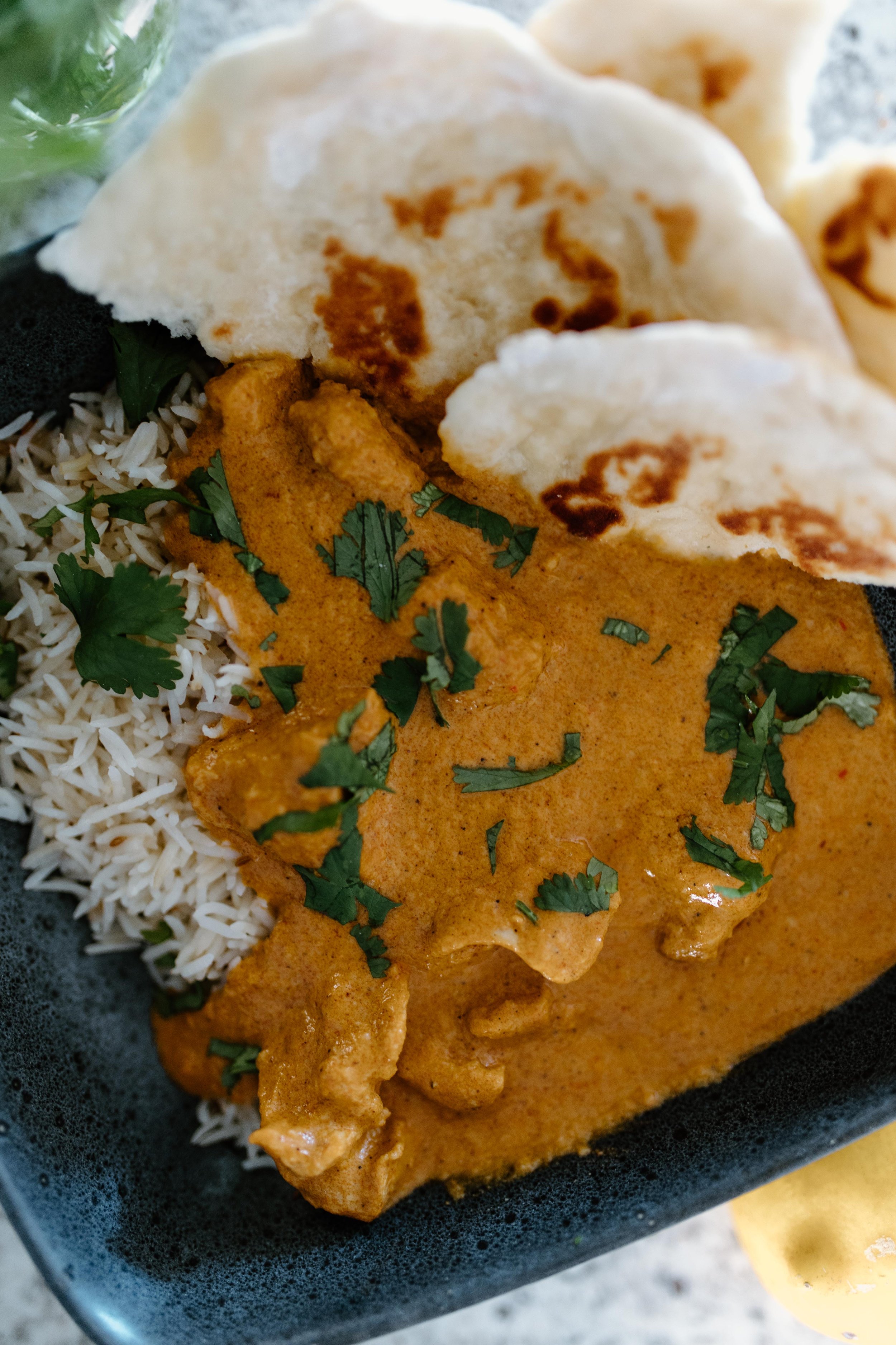 Slow cooker Indian butter chicken served with rice and garlic naan