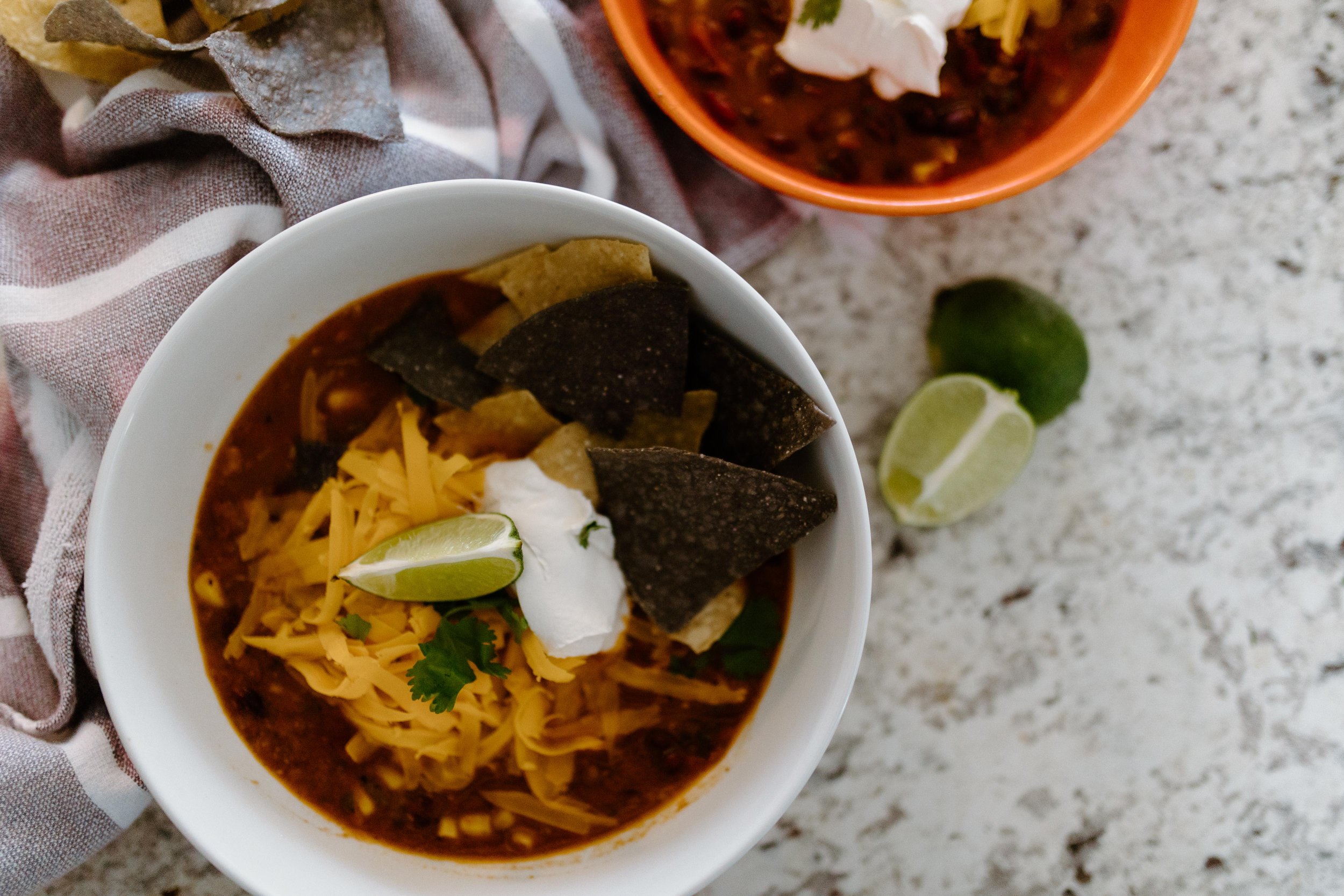 Easy Instant Pot chicken enchilada soup served with tortilla chips cheese and sour cream