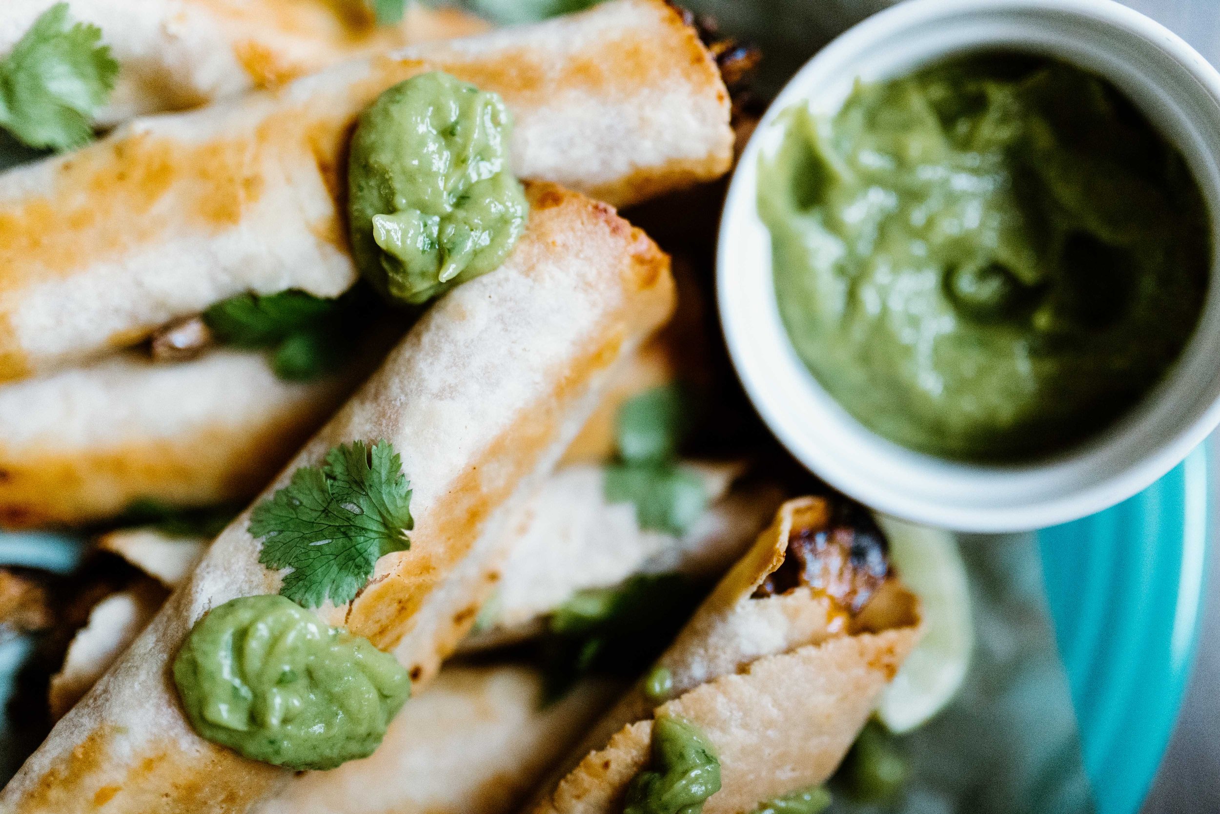 Ground turkey and vegetable taquitos can be served with salsa, sour cream, and avocado crema