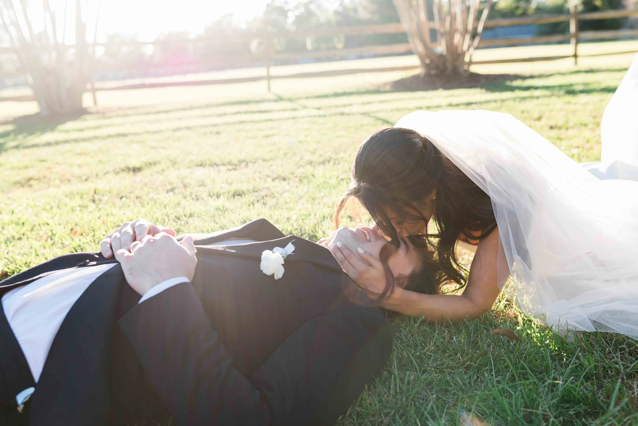 Couple lays on the ground and kisses right after saying I do in Myrtle Beach, SC.
