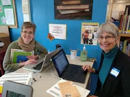 Volunteers help students check out books in the Blackstone Library
