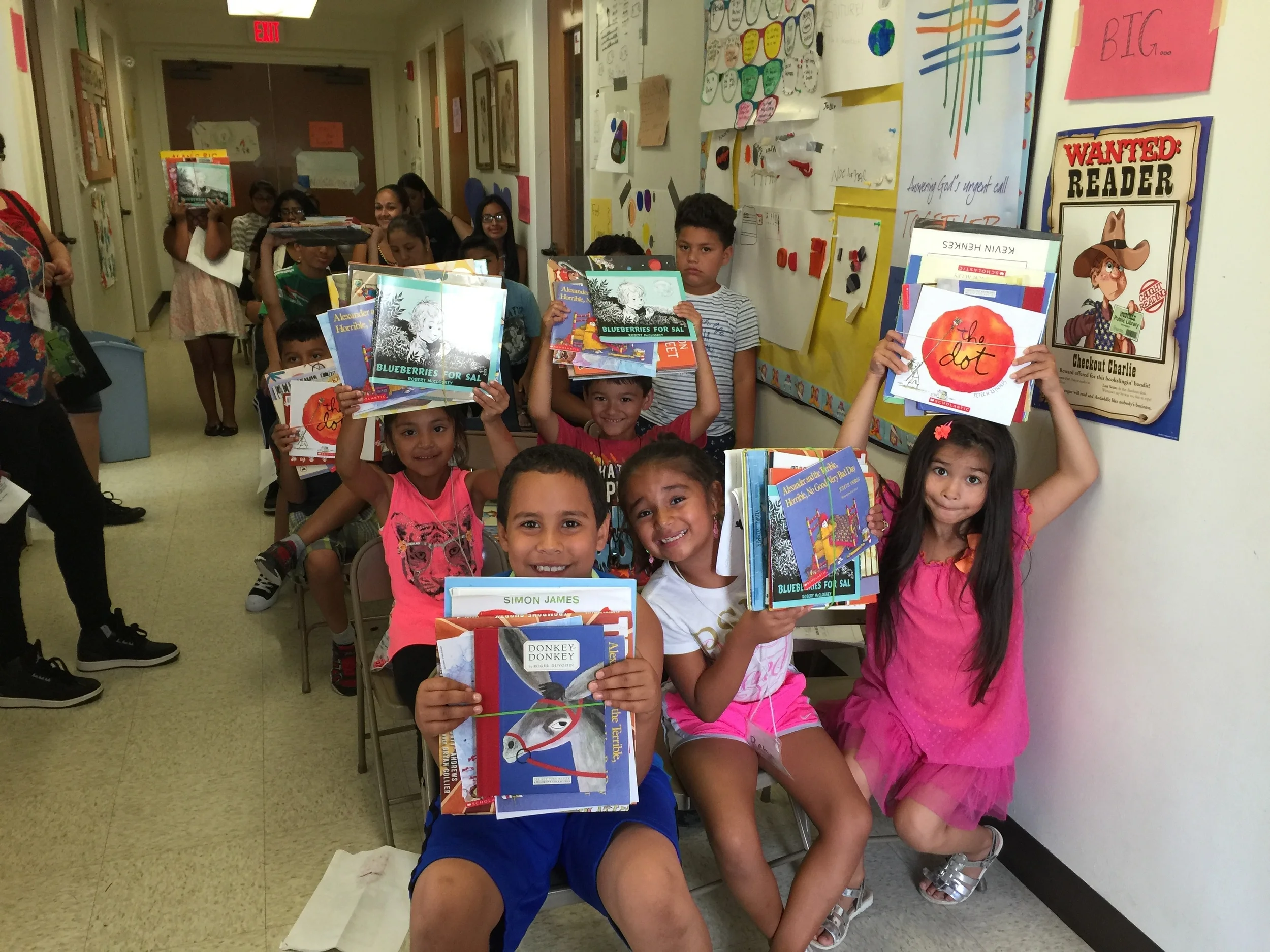 It's Christmas in July with children excited to receive books to take home and read.