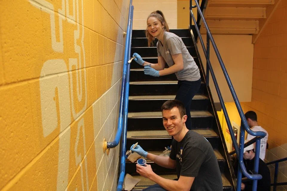 Volunteers paint the stairs at the 7th Annual MLK Day of Action