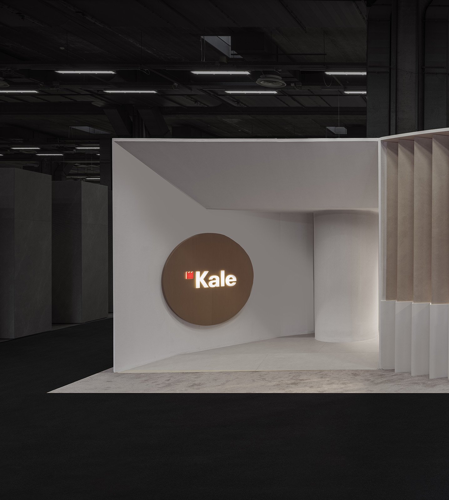  Neutral-tone exhibition stand entrance with minimal geometric walls and illuminated logo. 