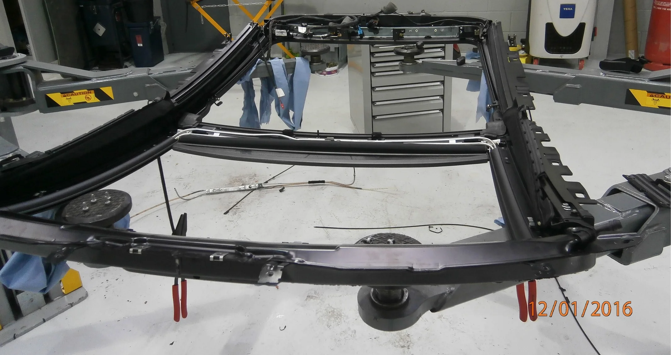 Roof assembly stripped and upside down, awaiting new cables.