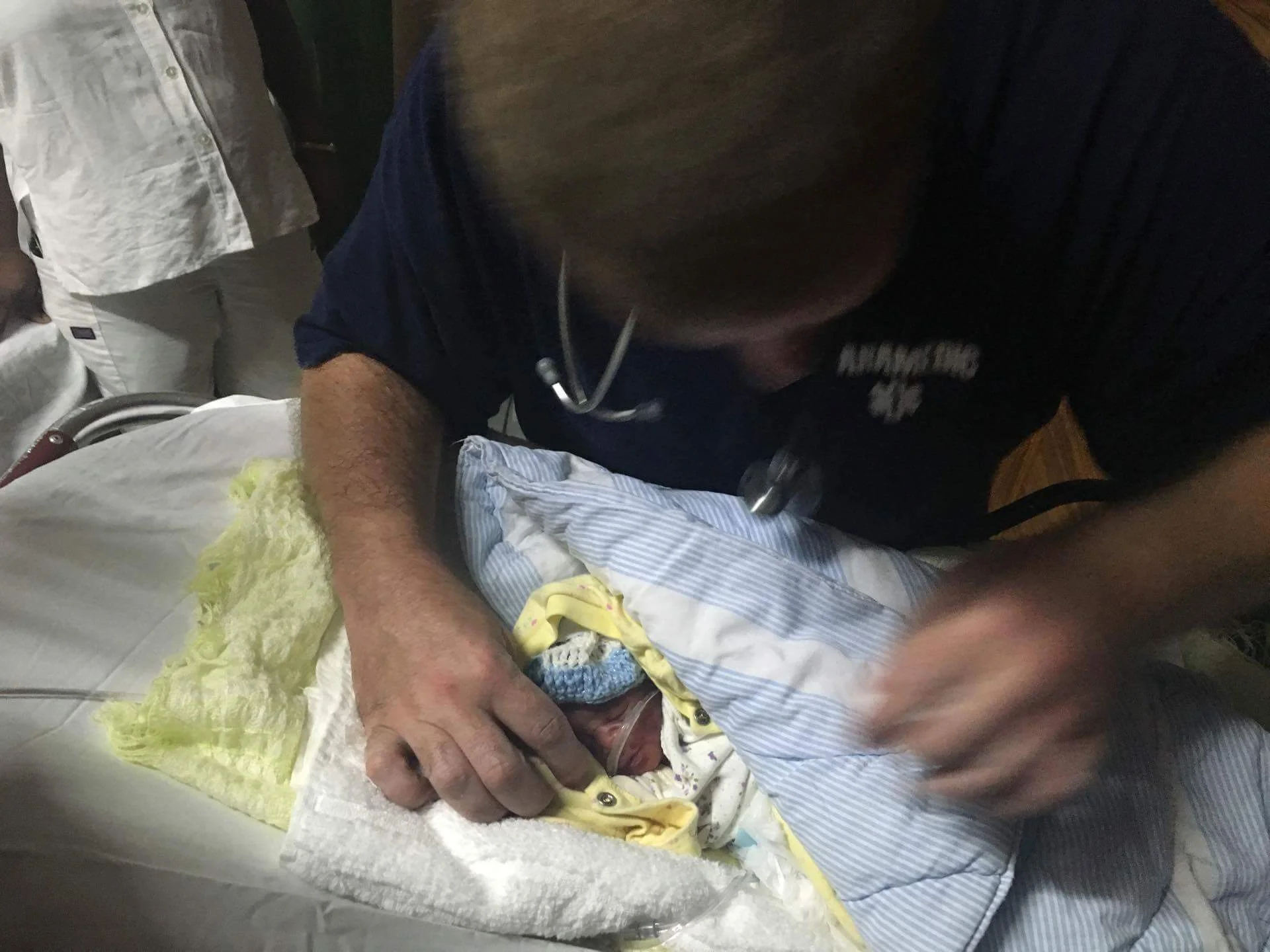This is me assessing Baby Boo Boo before we loaded him into the ambulance. It's not the best picture — but the most important to me from this trip. Notice that my finger would go from the bottom of his chin to the top of his head. He was so tiny and so precious.