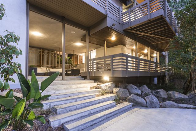 Downstairs an additional entertaining area with fireplace, bedroom and bath open to decks, patio, pool and lush grounds. 