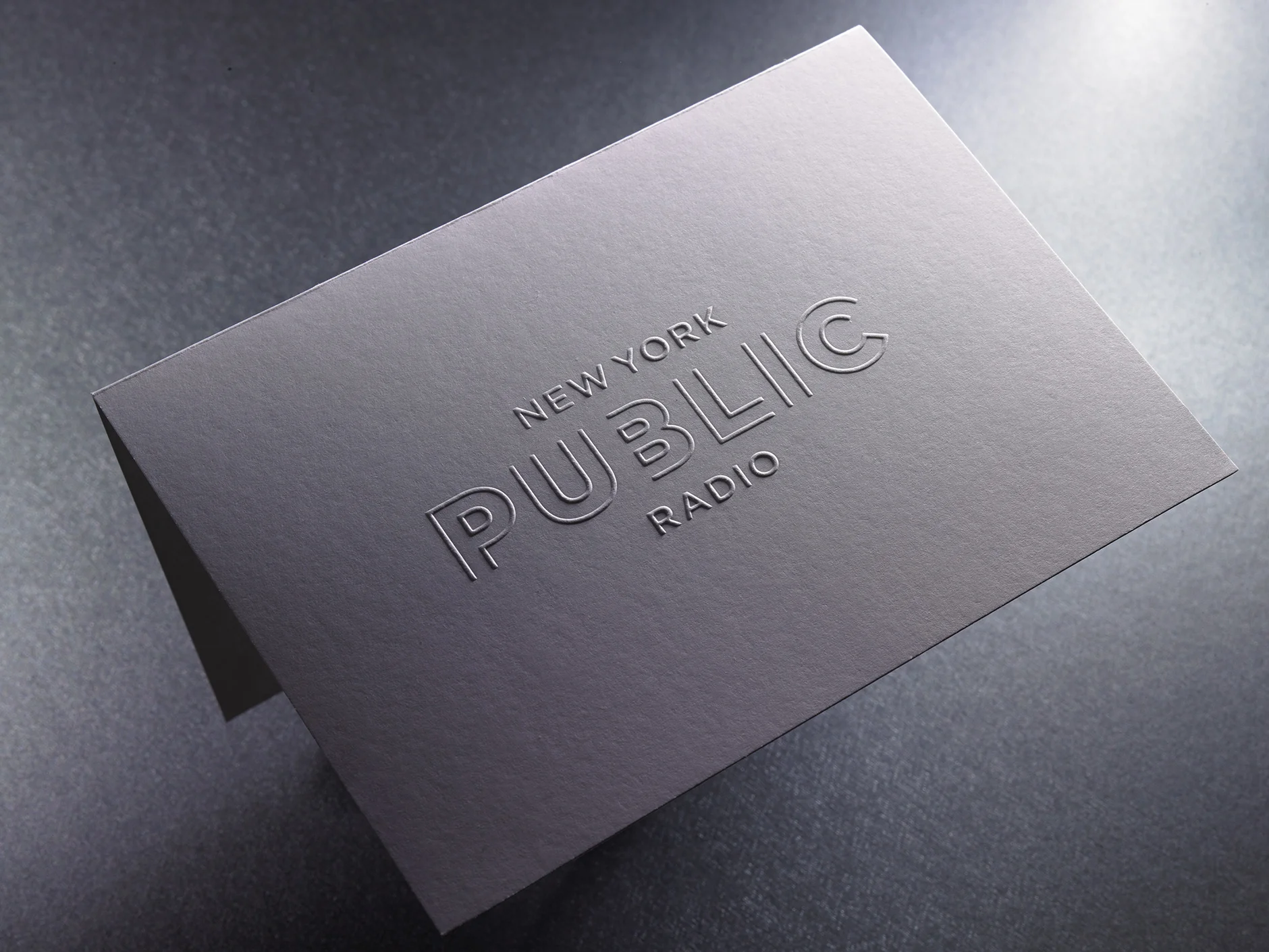 New York Public Radio Folded Notecard A quick way to send a powerful message, this notecard was blind-embossed with NYPR’s logo type on the front. A thick, uncoated smooth cover stock that was diescored and folded in half was used for this project.