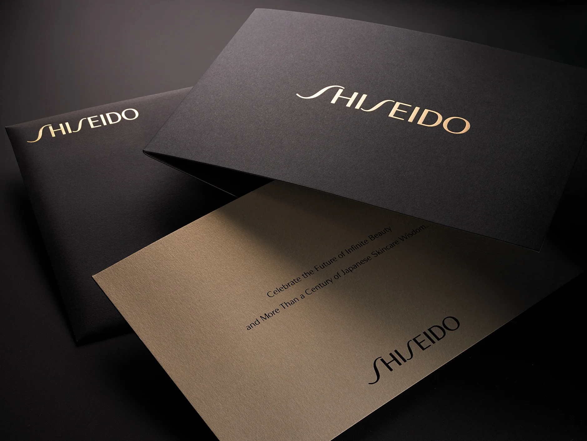 Shiseido Invite/Envelope Mailer For this beautiful mailer we gold foil-stamped a solid black uncoated envelope with the Shiseido logotype. The invite text was also black and gold foil-stamped and mounted with a solid black and pearlized bronze cover stock. Their clients loved the substantial and luxurious feel!