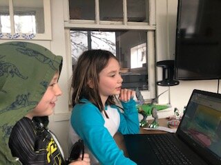 This Children's House student and his big sister, a former Bridgeview student, enjoy some remote learning.