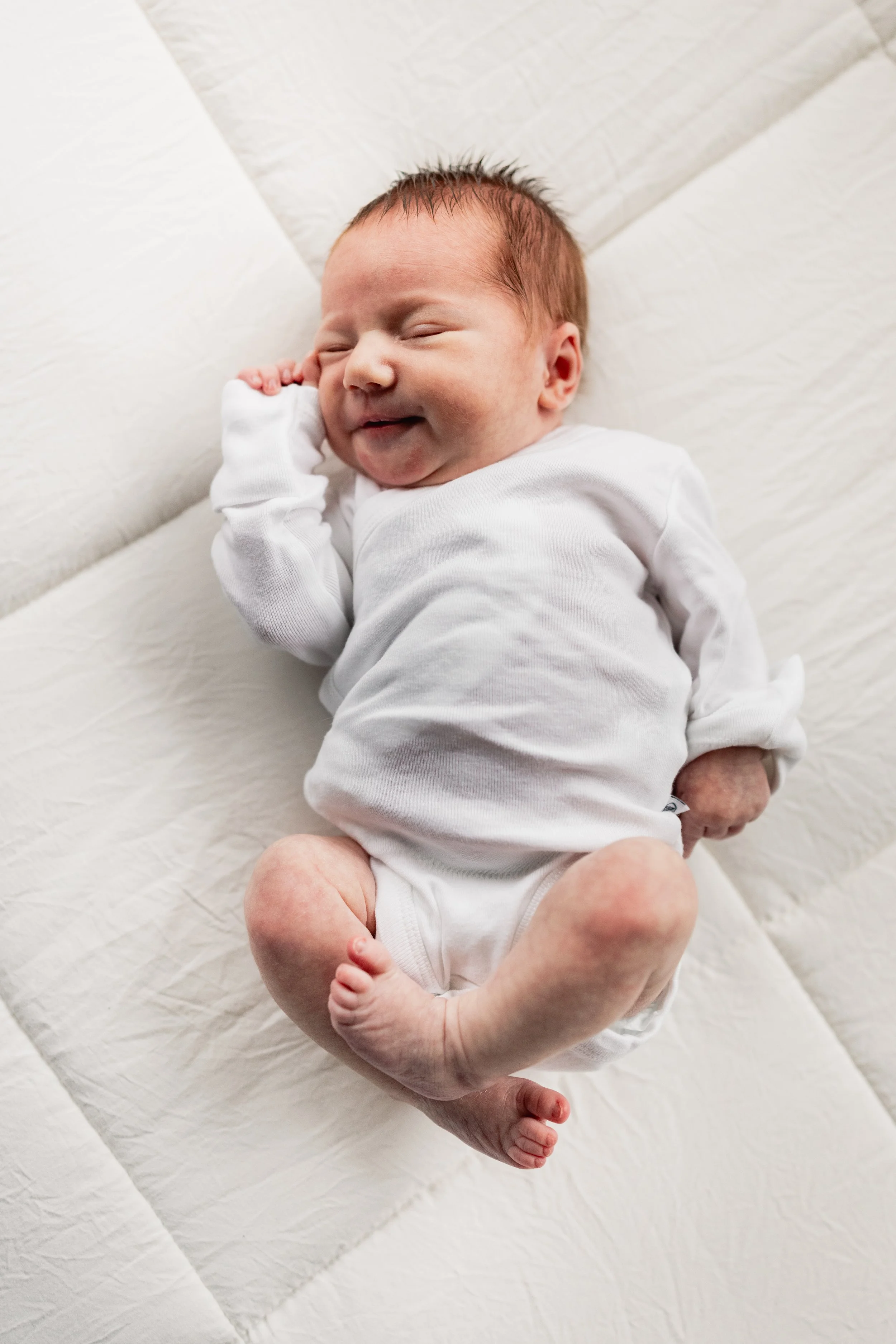 Seattle newborn photographer gently photographing a baby in a home settin