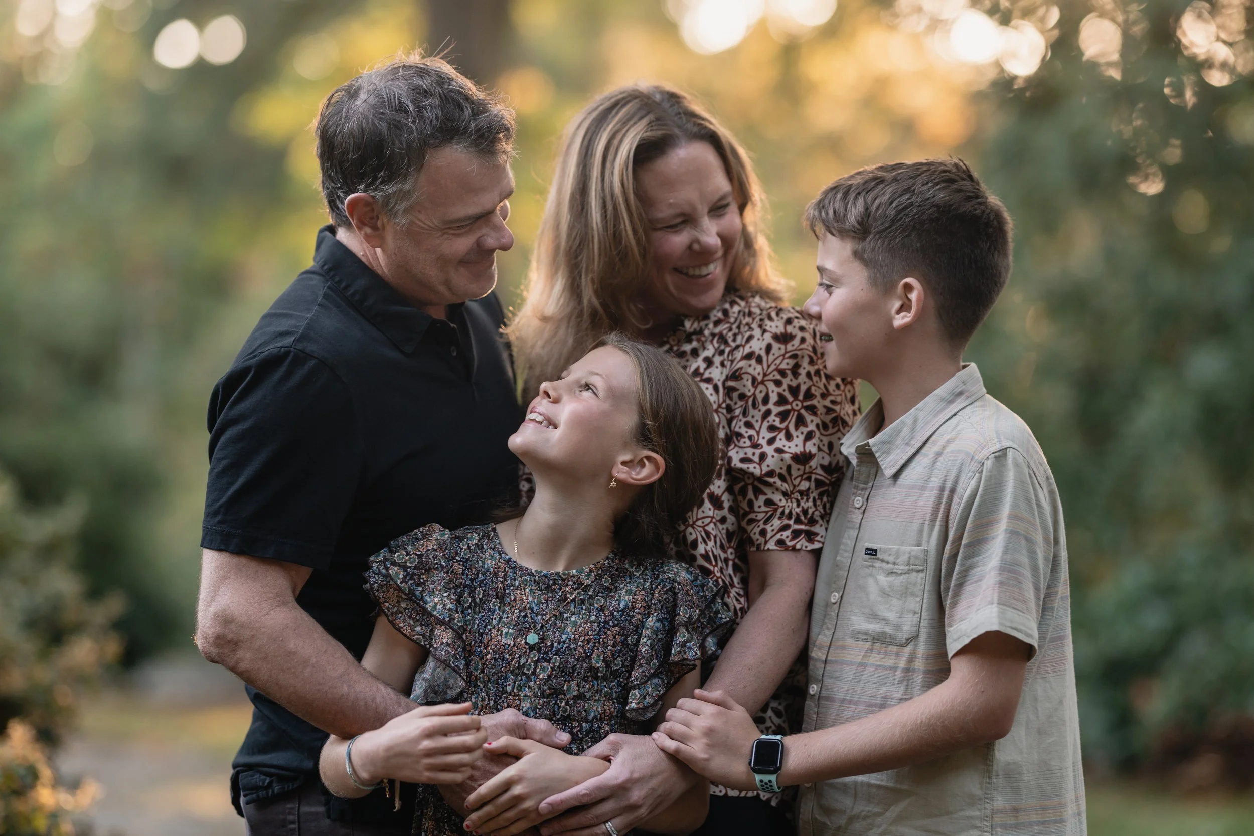 Candid family portrait at the Seattle Arboretum featuring parents and their two children during a professional Seattle family photography shoot.
