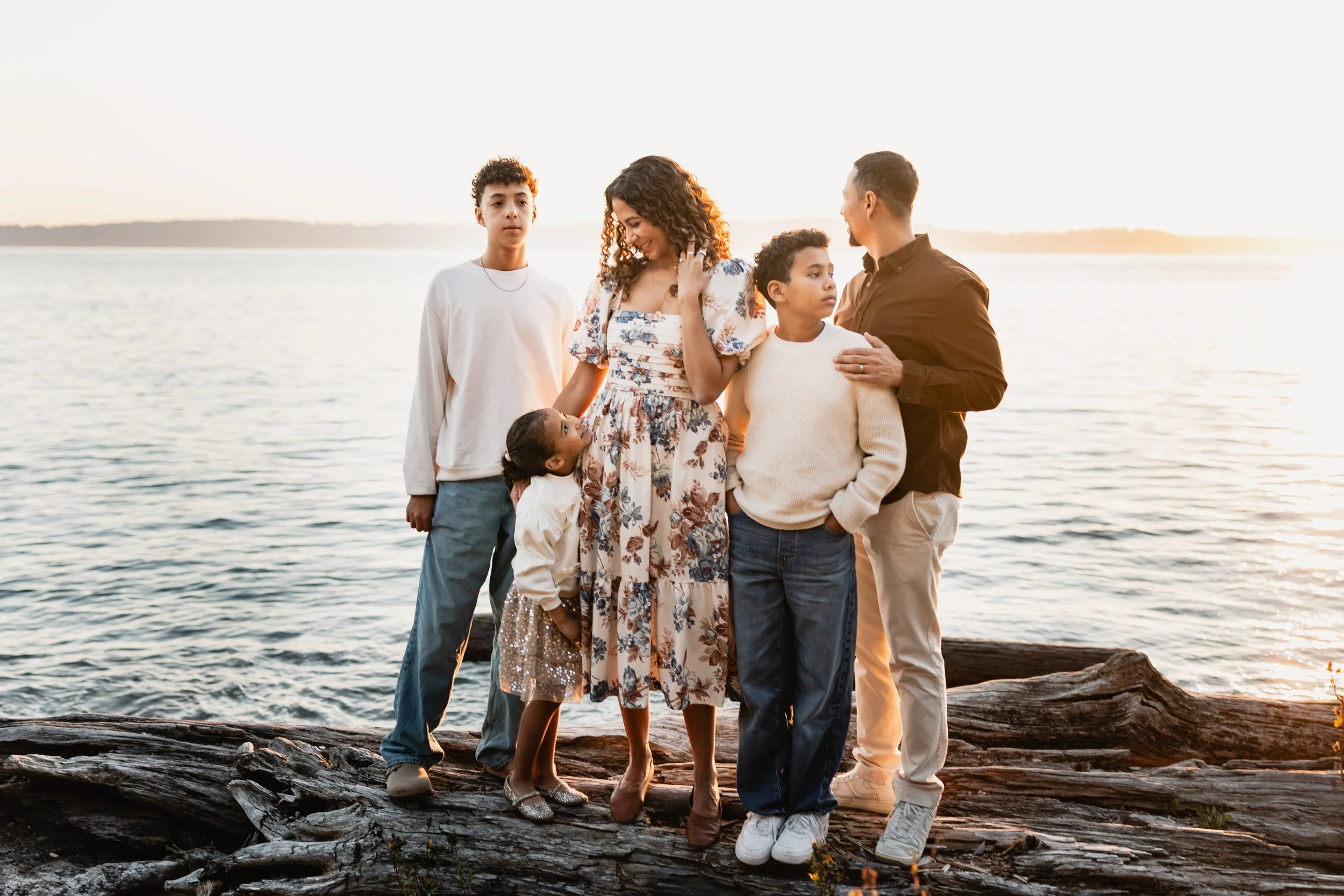 Family stands near the waters edge in west seattle for lifestyle family photos with Elena S Blair.