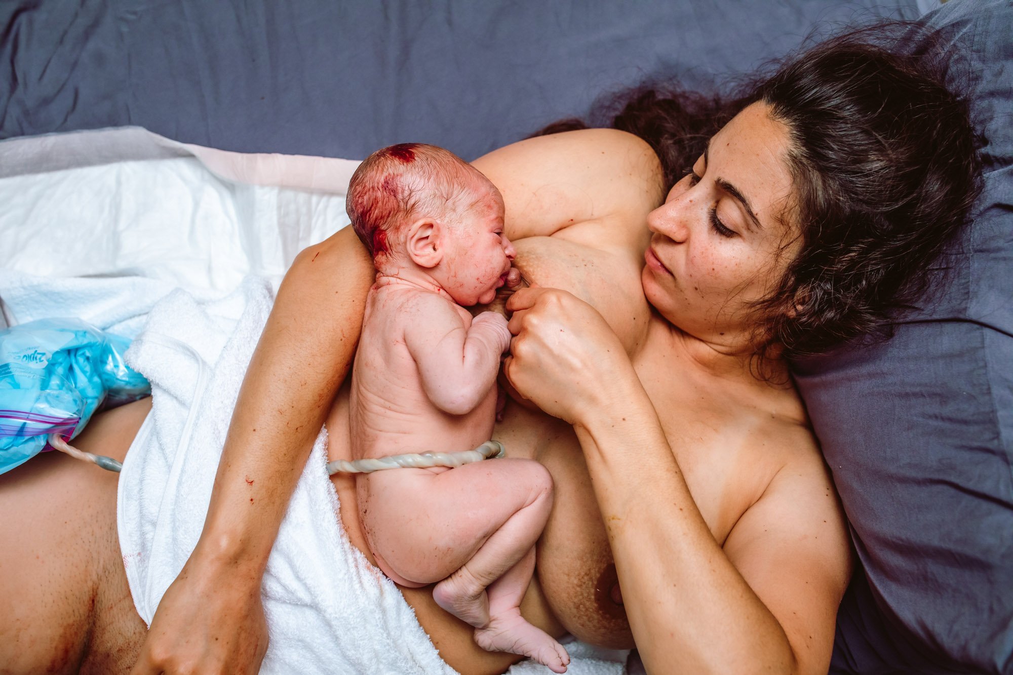 New born baby - girl with remainder of umbilical cord after successful  childbirth. Real birthing and new