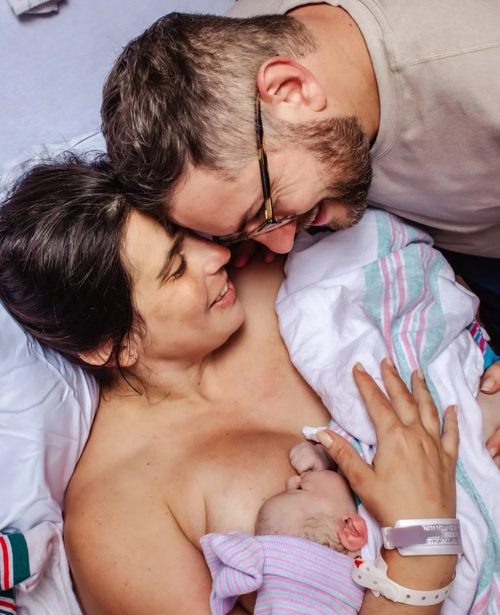 first time mom and dad hold baby girl at birth