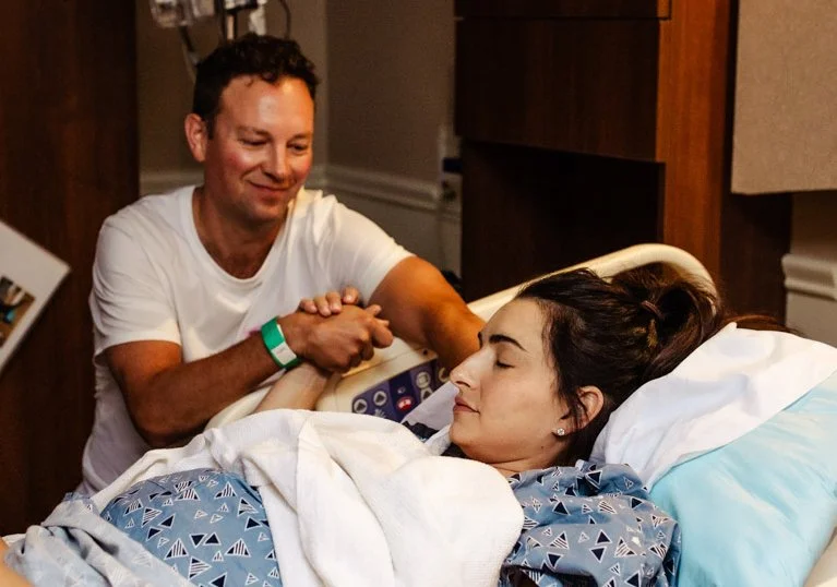 husband holding laboring wife's hand in boca regional labor and delivery