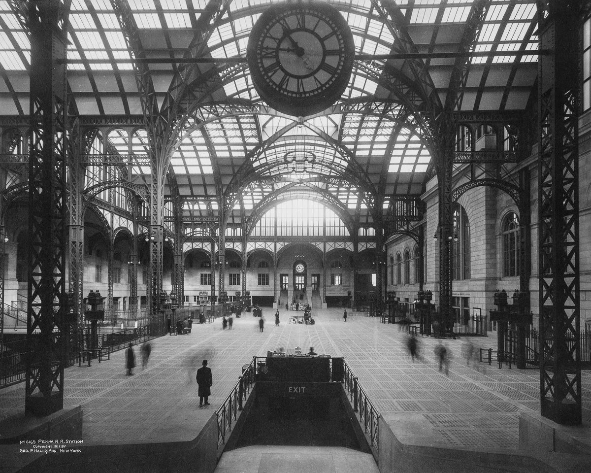 The original Pennsylvania Station was built from 1901-1910 by the Pennsylvania Railroad and featured an ornate marble and granite station house and train shed inspired by the Gare d'Orsay in Paris (the world's first electrified rail terminal). After a decline in passenger usage during the 1950s, the original station was demolished and reconstructed from 1963 to 1969, resulting in the current station. Future plans for Penn Station include the Gateway Project and the possibility of shifting some trains to the adjacent Farley Post Office, a building designed by the same architects as the original 1910 station.