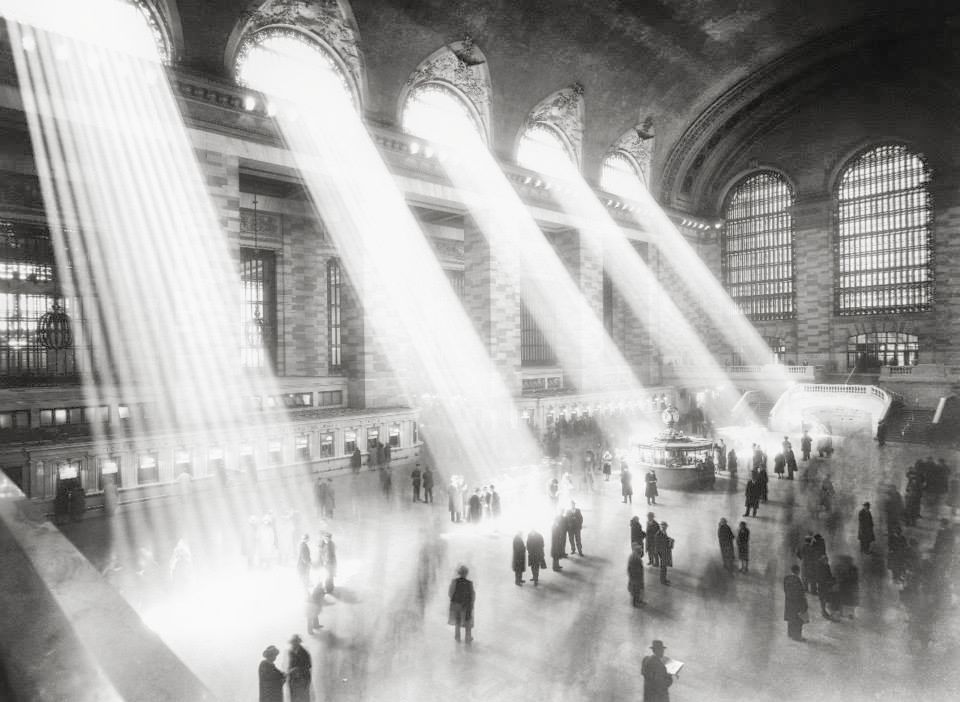 Grand Central Terminal main concourse (1923). The smoke inside is from cigarettes. At some point, the ceiling completely covered with a dark patch. It was formed by over 100 years of dirt and, mostly, the result of decades of smoking in the terminal. MTA's Marjorie Anders explains: "The remaining dirt is a combination of tarry nicotine from the millions of cigarettes, cigars and pipes once consumed in the Terminal by generations of travelers and the soot and steel dust that stuck to it. Smoking was banned in Grand Central Terminal in March 30, 2003, the same time the ban went into effect citywide." | Image: New York City, Department of Records