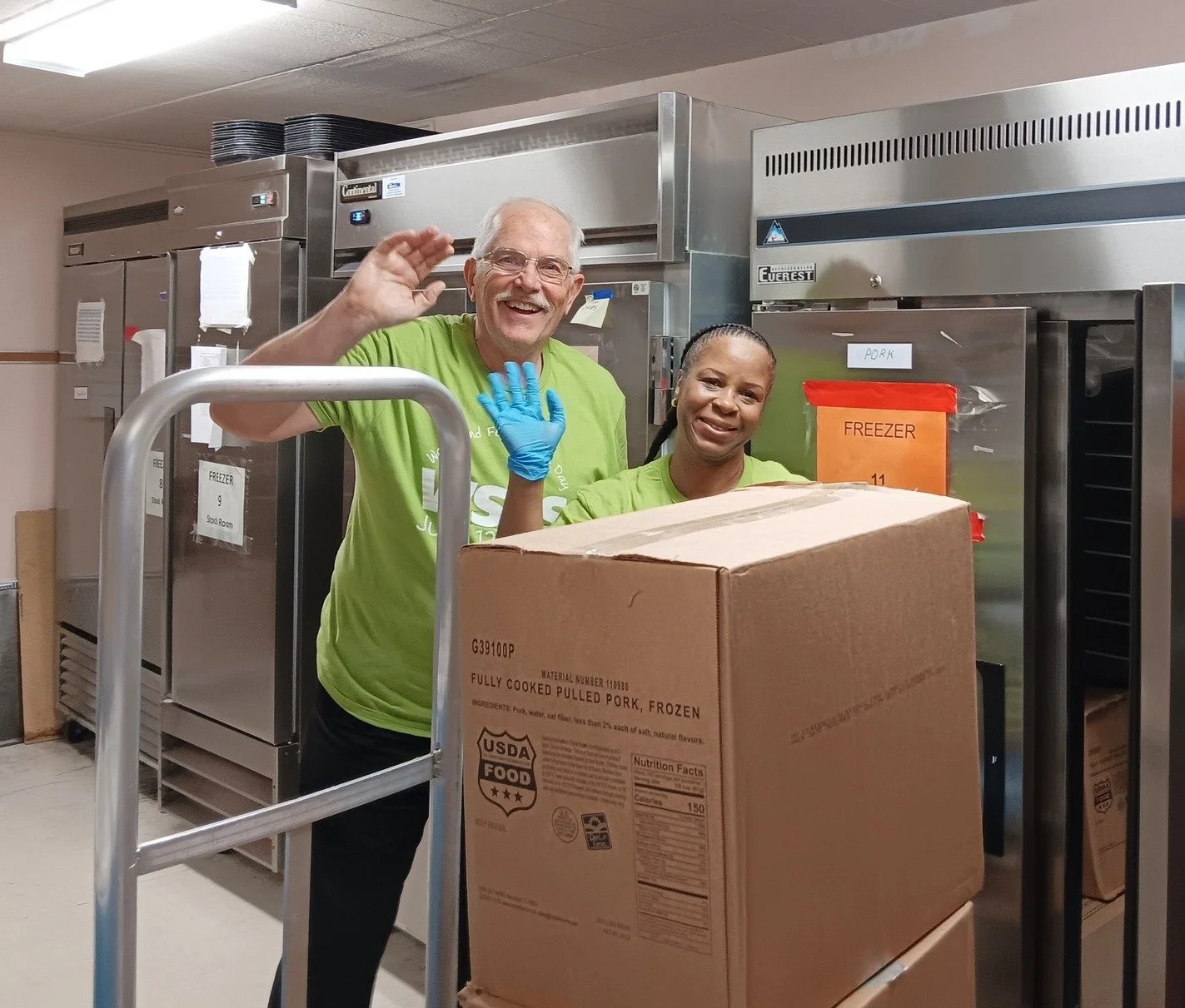 Two Jenkintown Food Cupboard volunteers with a box of groceries