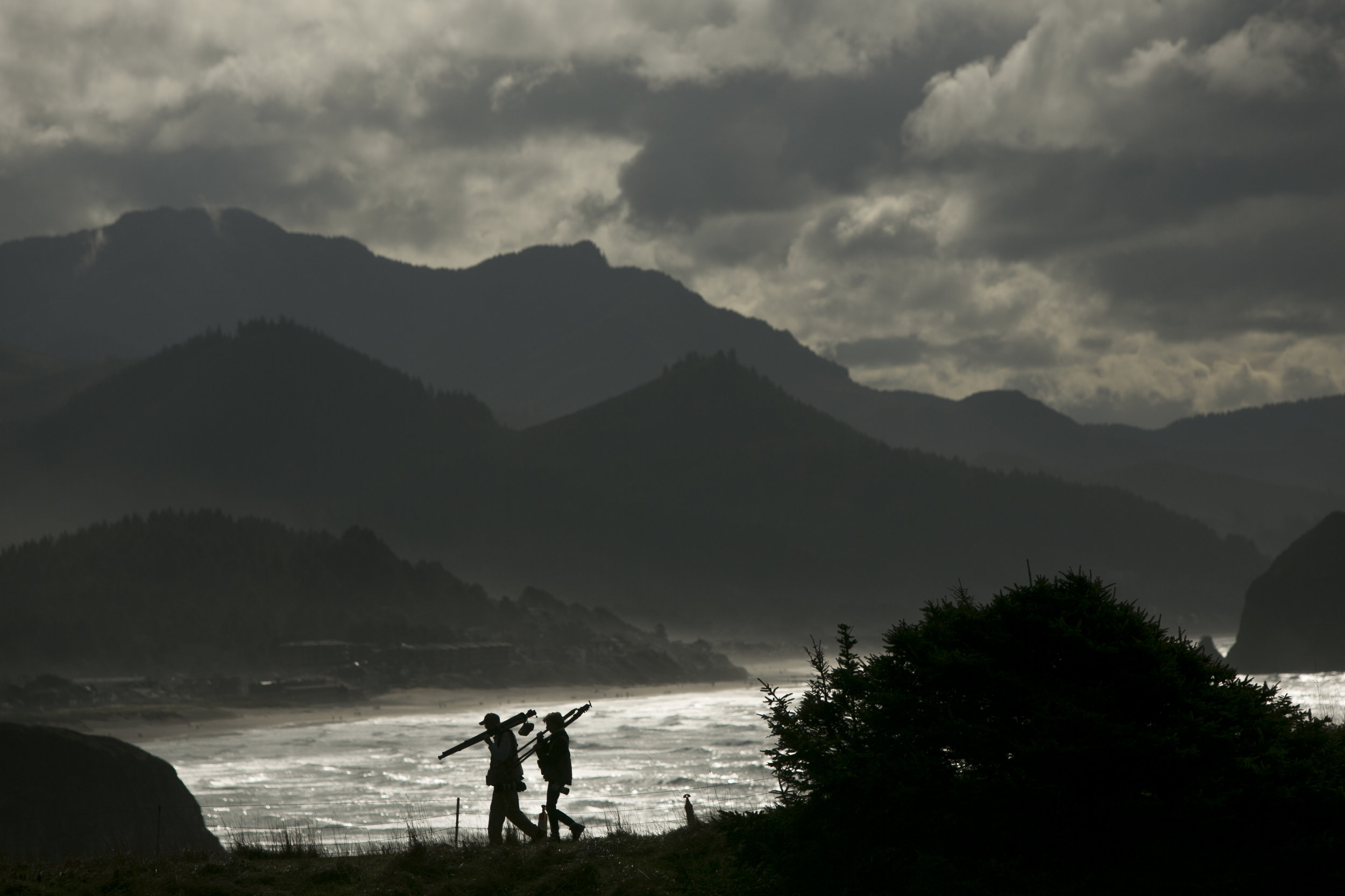  Two photographers carry their tripods along a ridge line near Canon Beach in Oregon. 