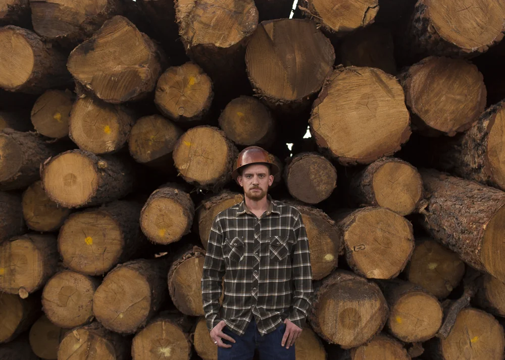  Mark Chamberlin, the general manager of the Grand Canyon Forest Products mill,&amp;nbsp;stands in front of a stack of logs at the mill in Williams, Arizona.  