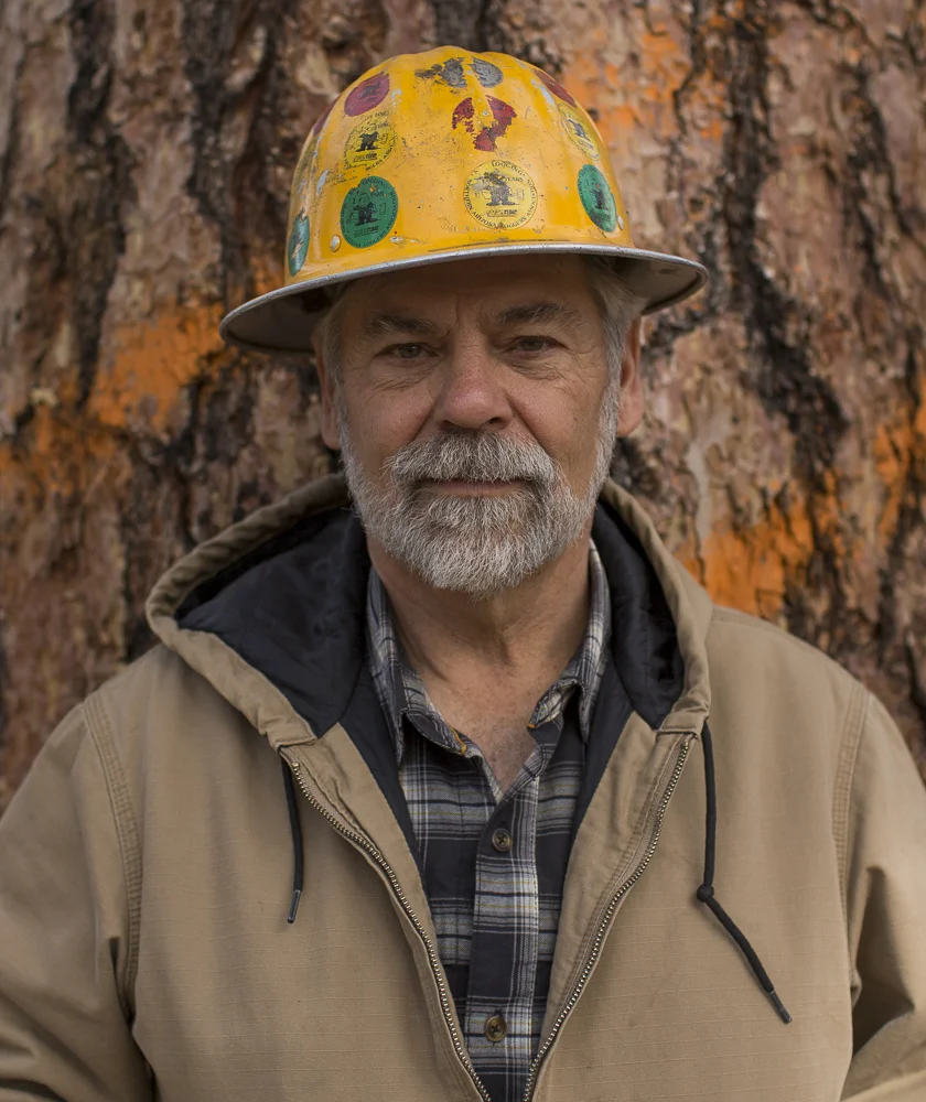   Ken Ribelin, a logger, stands in front of a tree marked to be cut down at the Chimney Springs forest restoration in Flagstaff, Arizona.  