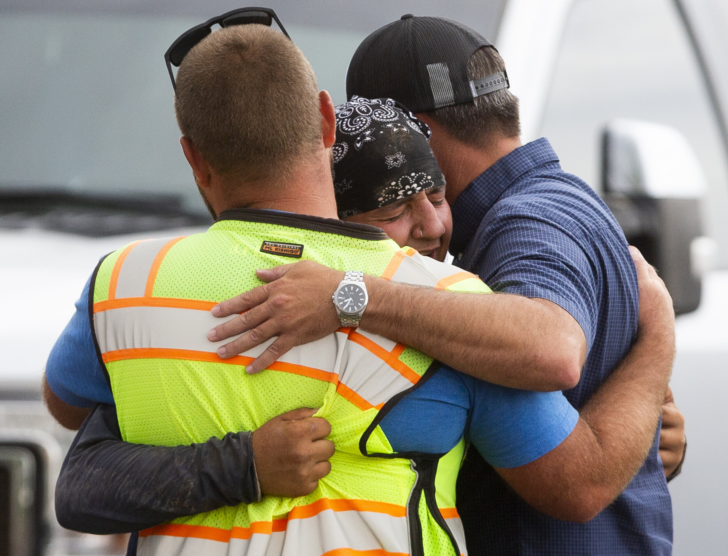  Construction worker Mario Nodal (center) embraces two coworkers after learning his uncle died alongside another worker who died at the site of a trench collapse near north 109th avenue and west Marshall avenue in Phoenix, Ariz.  